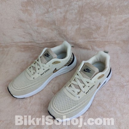 Nike Air Zoom running shoes in a light beige/tan colorway wi